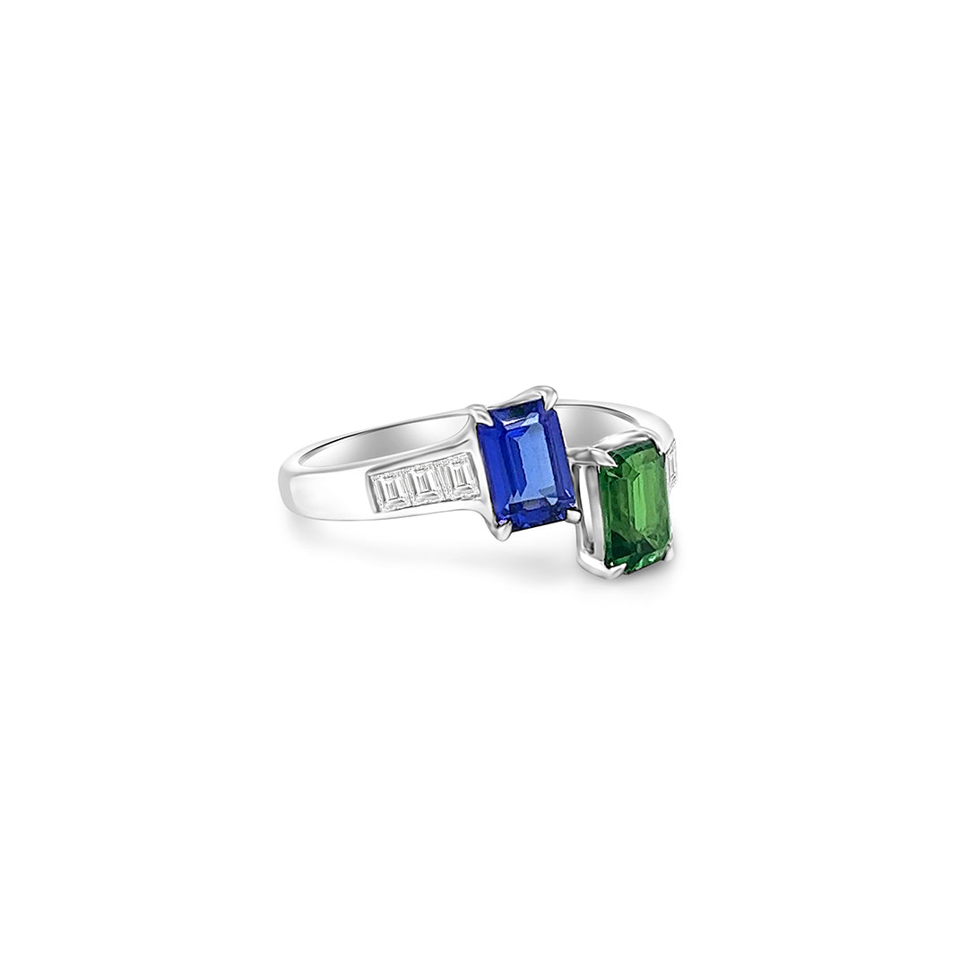 Two stunning gemstones - tsavorite and tanzanite - set in an elegant Toe Et Moi ring. Close-up of the exquisite green tsavorite gemstone in the Toe Et Moi ring. Mesmerizing violet-blue tanzanite gemstone showcased in the luxurious ring design. A side view of the Tsavorite & Tanzanite Ring highlighting the intricate craftsmanship. The Toe Et Moi ring featuring a harmonious blend of tsavorite and tanzanite gemstones.