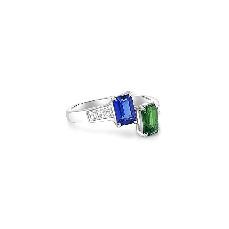 Two stunning gemstones - tsavorite and tanzanite - set in an elegant Toe Et Moi ring. Close-up of the exquisite green tsavorite gemstone in the Toe Et Moi ring. Mesmerizing violet-blue tanzanite gemstone showcased in the luxurious ring design. A side view of the Tsavorite & Tanzanite Ring highlighting the intricate craftsmanship. The Toe Et Moi ring featuring a harmonious blend of tsavorite and tanzanite gemstones.
