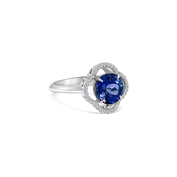 Round tanzanite and diamond halo ring with 2.60ct tanzanite center stone Blue tanzanite gemstone surrounded by sparkling diamonds in a halo setting Exquisite tanzanite and diamond ring, a perfect blend of elegance and opulence Luxurious round tanzanite ring set in white gold with diamond accents Brilliant blue tanzanite encircled by a halo of shimmering diamonds on an engagement ring band Captivating tanzanite and diamond jewelry, a symbol of timeless beauty and sophistication