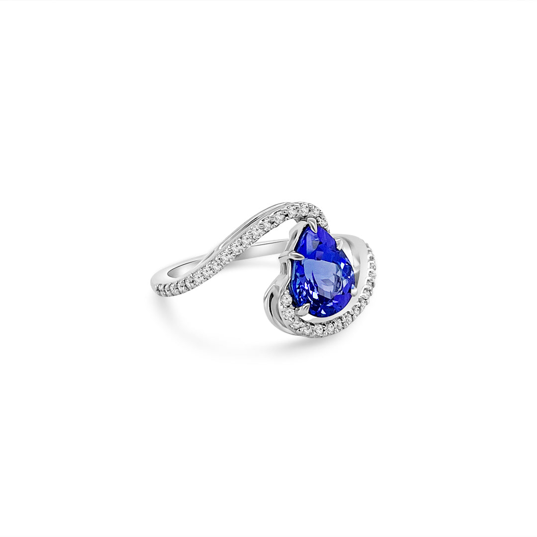 Main Image: "1.50ct Pear Shape Tanzanite & Diamond Ring" Side View: "Pear Shaped Tanzanite Gemstone Ring" Diamond Detail: "Diamond Halo Accent on Tanzanite Gemstone Ring" Elegance in Design: "Elegant Design with Pear Shaped Tanzanite" Customization Options: "Different Open Liners for Personalization" Versatile Elegance: "Versatile Gemstone Ring for Various Occasions"