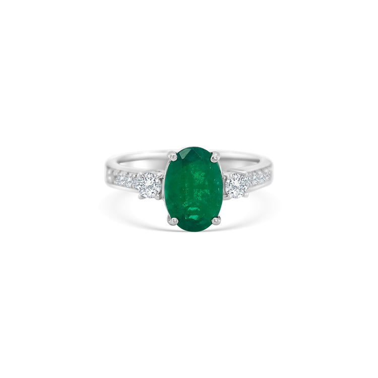 Oval emerald ring, emerald trilogy ring, emerald and diamond ring, diamond trilogy ring, diamond and emerald jewelry, fine jewelry, elegant ring, gemstone ring, luxury jewelry, three-stone ring, green gemstone ring."