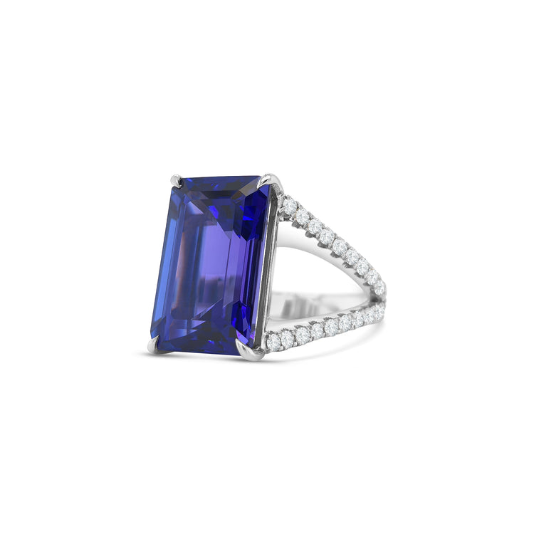 Emerald cut tanzanite ring with split shank diamond band, Elegant emerald cut tanzanite and diamond ring with split shank design, Split shank ring featuring vibrant emerald cut tanzanite center stone, White gold ring with emerald cut tanzanite and diamond accents, Luxurious emerald cut tanzanite ring framed by split shank diamonds, Statement ring with emerald cut tanzanite and diamond split shank, Modern split shank diamond ring with vivid emerald cut tanzanite