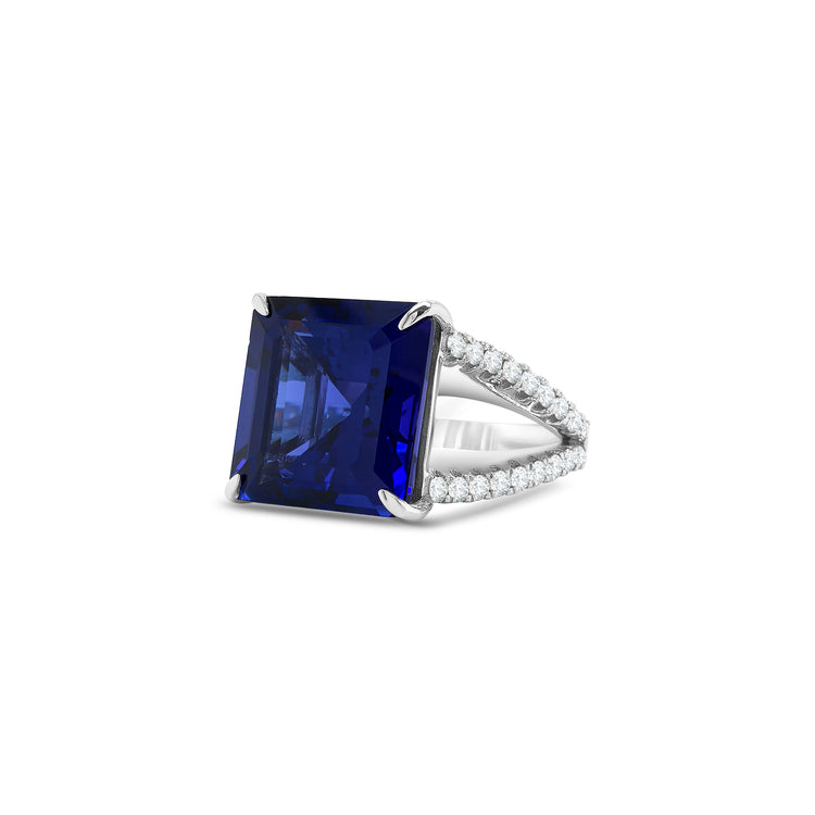 Square emerald-cut tanzanite ring with split shank diamond band, Elegant split shank ring featuring square emerald tanzanite center stone, Luxury tanzanite and diamond ring with emerald-cut design, White gold ring with square emerald tanzanite and split shank detail, Bold emerald-cut tanzanite ring with sparkling diamond split band, Square tanzanite gemstone ring with modern split shank setting, Sophisticated split shank diamond ring with emerald-cut tanzanite centerpiece