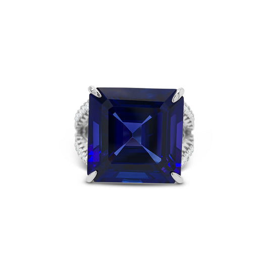 Square emerald-cut tanzanite ring with split shank diamond band, Elegant split shank ring featuring square emerald tanzanite center stone, Luxury tanzanite and diamond ring with emerald-cut design, White gold ring with square emerald tanzanite and split shank detail, Bold emerald-cut tanzanite ring with sparkling diamond split band, Square tanzanite gemstone ring with modern split shank setting, Sophisticated split shank diamond ring with emerald-cut tanzanite centerpiece