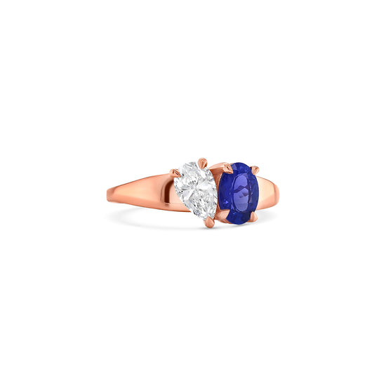 Elegant oval-cut tanzanite ring flanked by sparkling pear-shaped diamonds, set in a polished metal band.