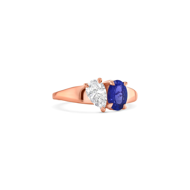 Elegant oval-cut tanzanite ring flanked by sparkling pear-shaped diamonds, set in a polished metal band.