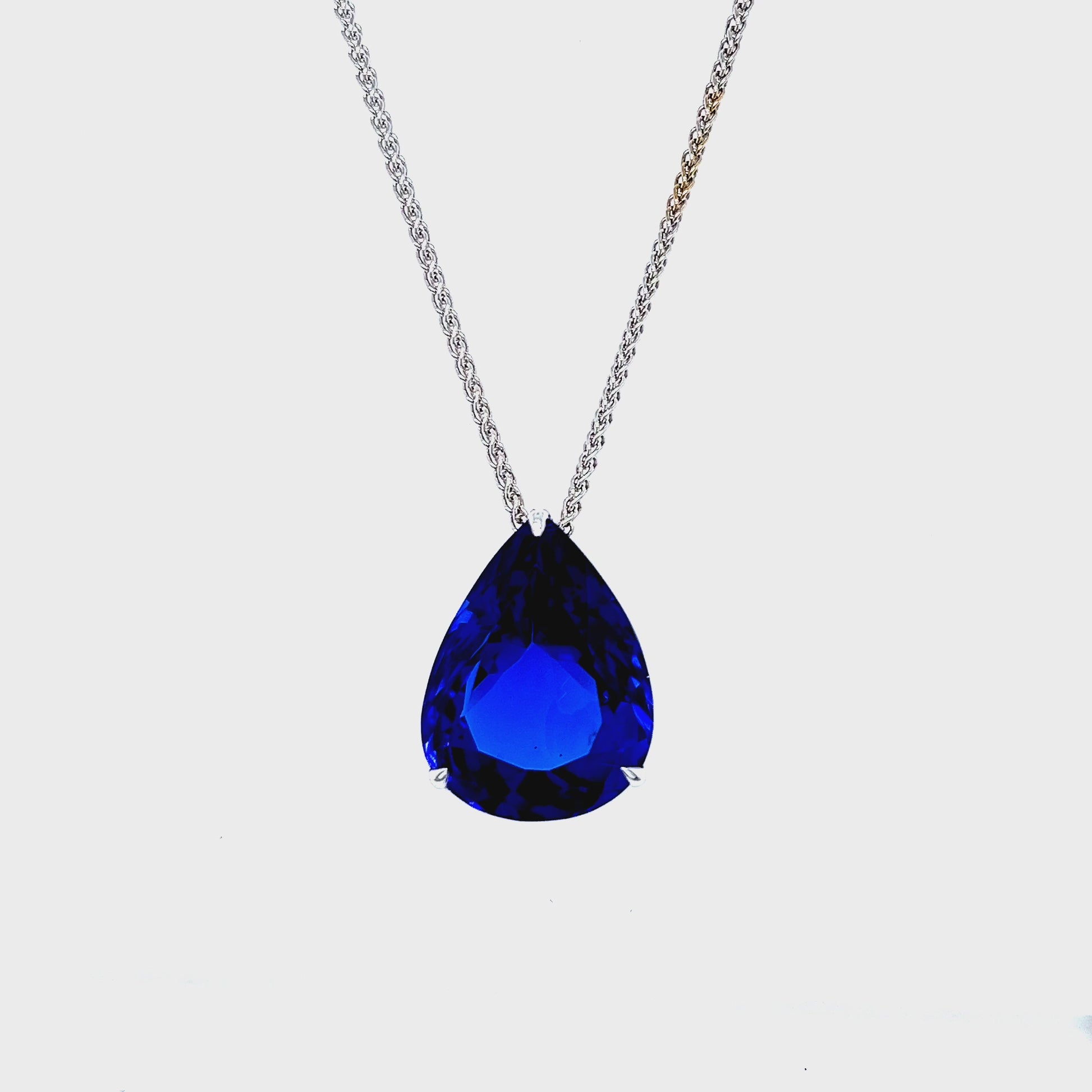 Floating Pear-Shaped Tanzanite Pendant" "20.10ct Tanzanite Gemstone Pendant" "Luxurious Purple Tanzanite Necklace" "Elegant Pear-Cut Tanzanite Jewelry" "Delicate Chain Pendant with Tanzanite" "Exquisite Craftsmanship Tanzanite Necklace" "Statement Gemstone Necklace" "Vivid Purple and Violet Tanzanite Pendant" "Pear-Shaped Tanzanite Suspended Pendant" "Timeless and Opulent Tanzanite Jewelry"