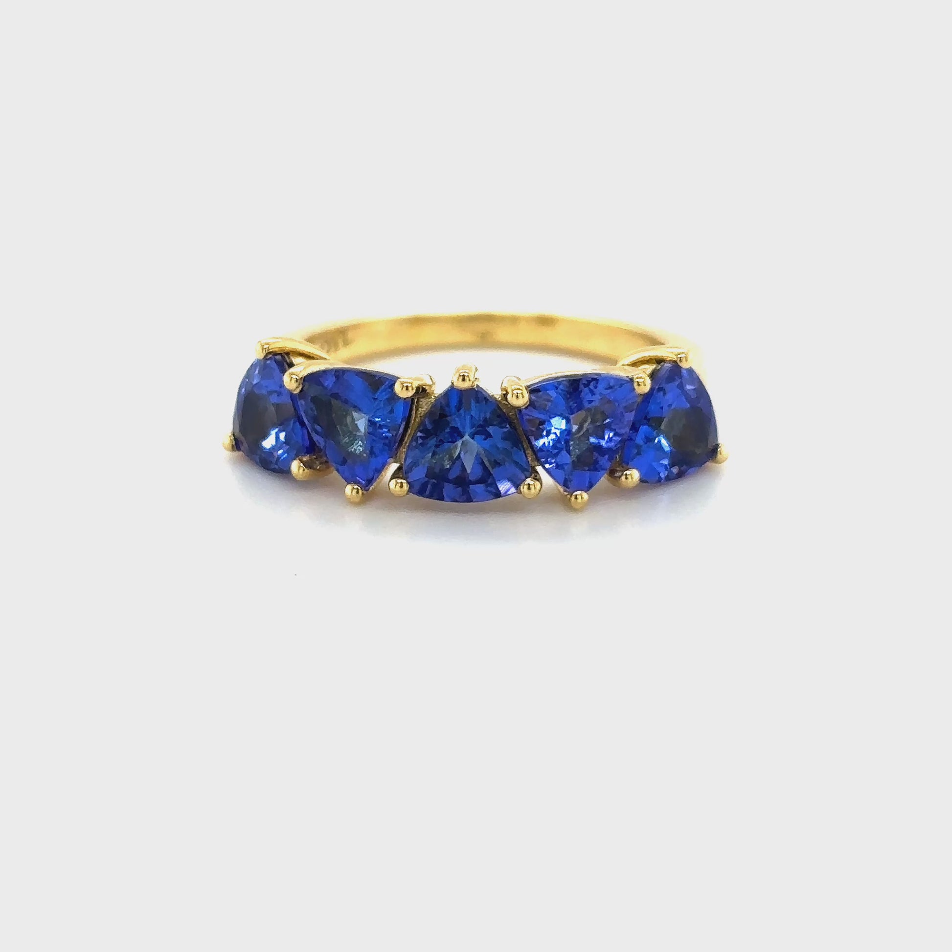 trillion tanzanite ring, half eternity ring, tanzanite eternity band, trillion cut gemstone ring, women’s tanzanite jewelry, fine gemstone ring, luxury eternity band, white gold tanzanite ring, elegant gemstone eternity ring, tanzanite half band
