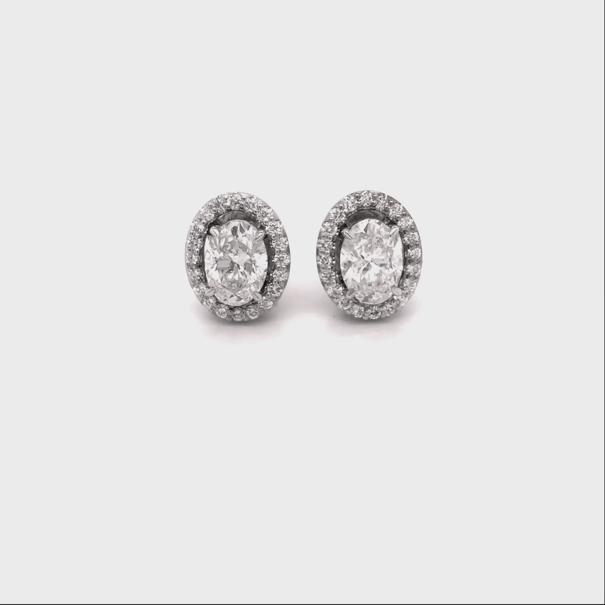 oval diamond halo earrings, diamond stud earrings, oval cut diamond jewelry, halo diamond earrings, elegant diamond studs, women’s fine jewelry, classic diamond earrings, oval halo stud earrings, luxury diamond jewelry, sparkling diamond earrings