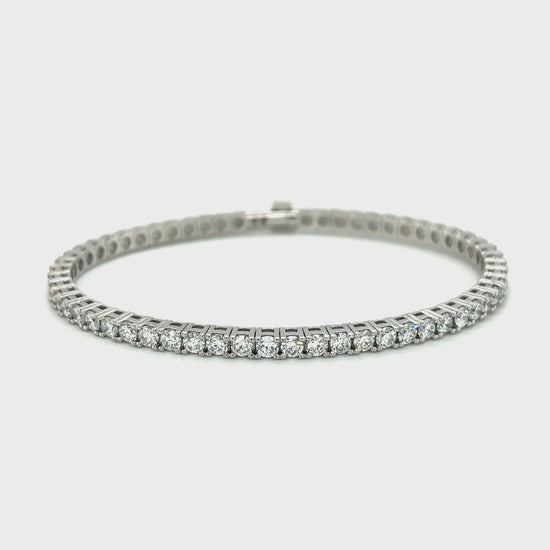 Diamond tennis bracelet with a row of round-cut diamonds set in white gold.