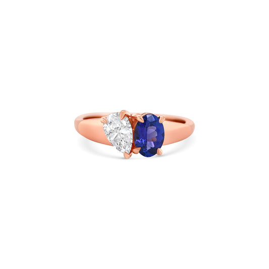 Elegant oval-cut tanzanite ring flanked by sparkling pear-shaped diamonds, set in a polished metal band.
