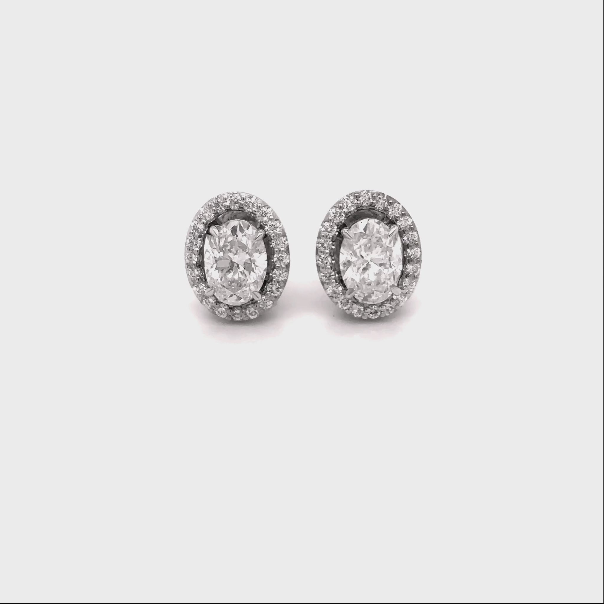 oval diamond halo earrings, diamond stud earrings, oval cut diamond jewelry, halo diamond earrings, elegant diamond studs, women’s fine jewelry, classic diamond earrings, oval halo stud earrings, luxury diamond jewelry, sparkling diamond earrings