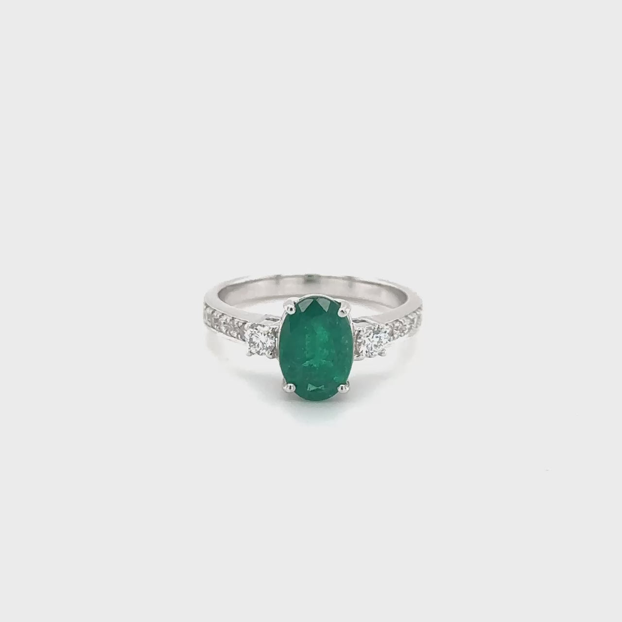 Oval emerald ring, emerald trilogy ring, emerald and diamond ring, diamond trilogy ring, diamond and emerald jewelry, fine jewelry, elegant ring, gemstone ring, luxury jewelry, three-stone ring, green gemstone ring."