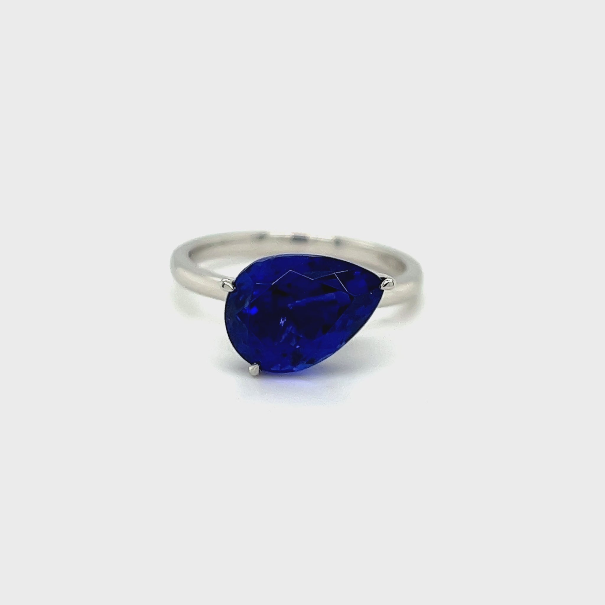 Alt Tag: Pear Shaped Tanzanite Solitaire Ring - Front View Alt Tag: Close-up of 4.90ct Tanzanite Gemstone Alt Tag: Elegant Pear-Cut Tanzanite Jewelry Alt Tag: Luxurious Tanzanite Engagement Ring Alt Tag: Pear Tanzanite Ring in Lustrous Metal Setting Alt Tag: Deep Violet and Blue Tanzanite Solitaire Alt Tag: Exquisite 4.90ct Tanzanite Solitaire Ring Alt Tag: Fine Gemstone Jewelry for Special Occasions Alt Tag: Pear Tanzanite Ring - Side Profile Alt Tag: Tanzanite Solitaire in Modern Classic Design