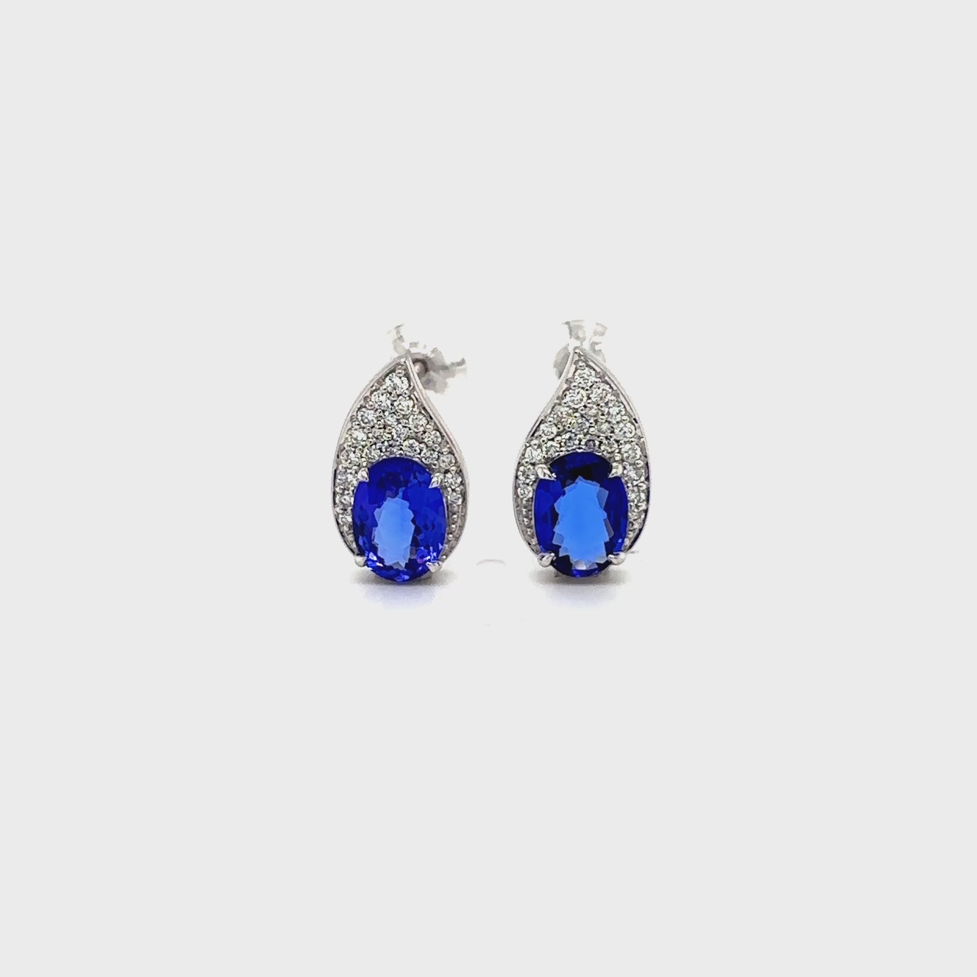 Tanzanite and diamond teardrop earrings, oval tanzanite diamond earrings, blue tanzanite and diamond stud earrings, white gold tanzanite teardrop earrings, luxury tanzanite and diamond earrings for women, elegant blue gemstone diamond earrings, natural tanzanite and diamond cluster earrings, fine jewelry tanzanite diamond earrings, sapphire blue tanzanite and diamond earrings, teardrop design tanzanite and diamond earrings.