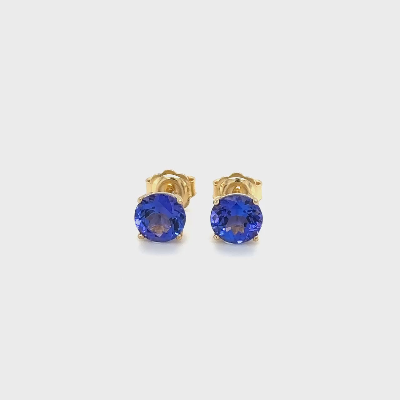 Round Tanzanite stud earrings, sparkling Tanzanite studs, elegant Tanzanite ear studs, precious Tanzanite gems, classic round Tanzanite earrings, beautiful blue Tanzanite studs, stunning Tanzanite jewelry, dainty Tanzanite studs, exquisite round Tanzanite earrings, vibrant Tanzanite studs.