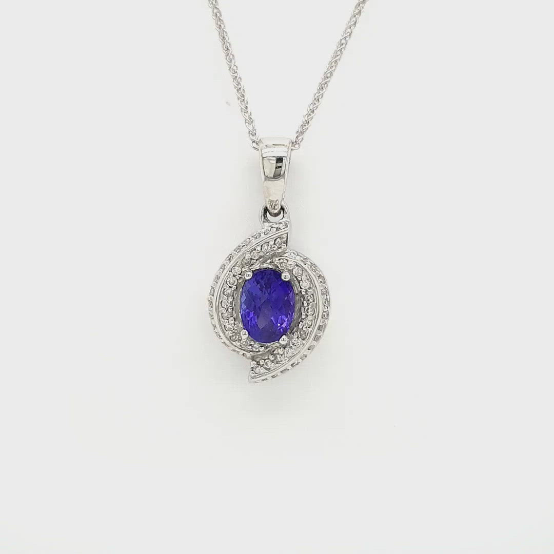 A captivating Oval Tanzanite pendant, intricately designed with a Diamond swirl, elegant Tanzanite and Diamond pendant, stylish swirl pendant with Oval Tanzanite and Diamonds, exquisite jewelry featuring an Oval Tanzanite and Diamond swirl design.